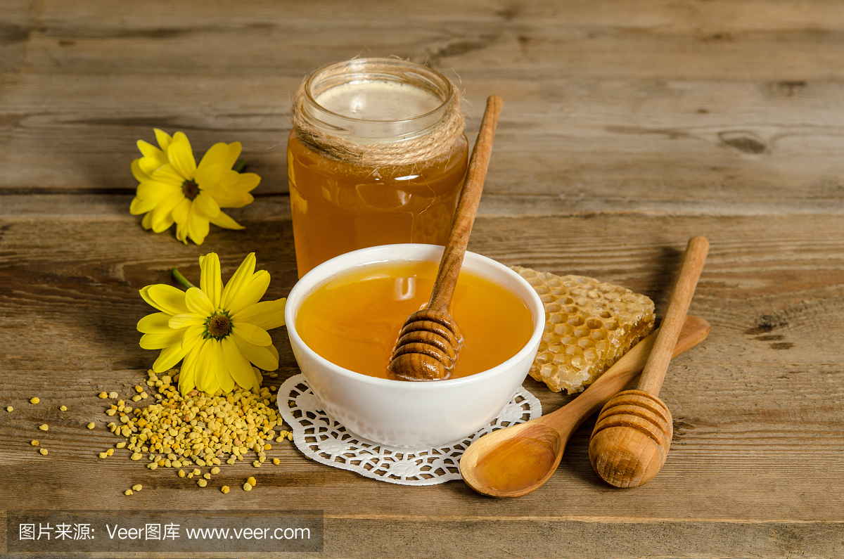 木质背景上的蜂产品(蜂蜜、花粉、蜂巢)